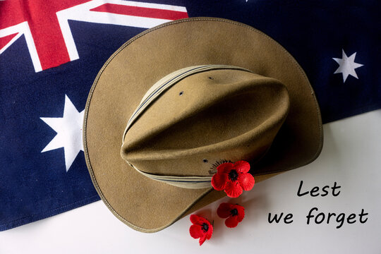 Royal Australian Air Force RAAF diggers slouch hat with blue trim to show area of service against an Australian flag with red poppies for Anzac Day and Remembrance Day. Top down view.