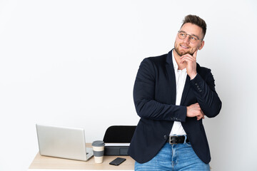 Russian man in a office isolated on white background thinking an idea while looking up