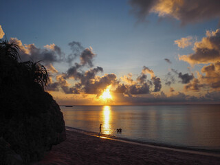 海に輝く光の道を挟んで遊ぶ子供たちのシルエット