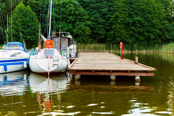 moored sailboats on a pier calm early morning. summer sailing vacations.