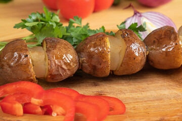 baked potatoes on a wooden plate. Grilled potatoes with fresh vegetables

