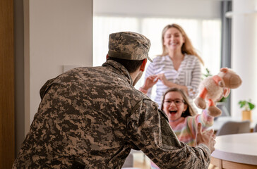 Soldier surprised his family by coming home, the daughter runs towards him to hug him.
