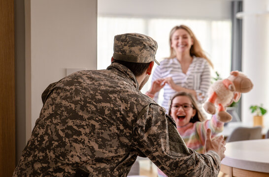 Soldier surprised his family by coming home, the daughter runs towards him to hug him. - Powered by Adobe