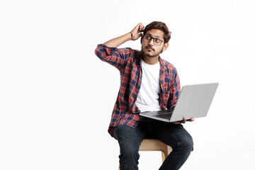 Young indian man thinking some idea when working on laptop.