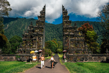 Happy couple having fun in Asia. Couple at the Bali gate. A man and a woman traveling on the island of Bali Indonesia. The couple travels the world. Man and woman in a Balinese temple at sunset