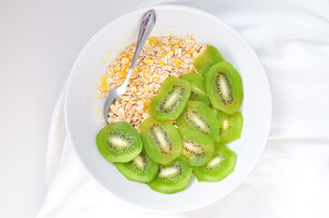 a plate of delicious oatmeal with green kiwi in the morning
