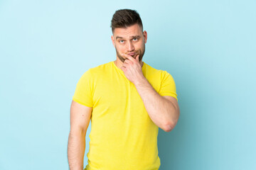 Russian handsome man isolated on blue background thinking