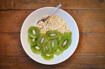 a plate of delicious oatmeal with green kiwi in the morning