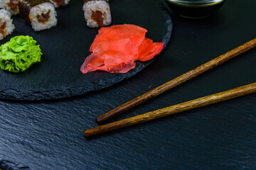 Sushi maki roll with tuna, wasabi and ginger on a slate board. Japanese food