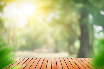 Blur green nature bokeh with sun light on copy space empty old wood table abstract background.