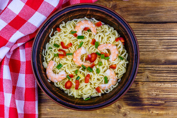 Instant noodle with shrimps, red pepper and green onion in a ceramic bowl. Japanese food. Top view