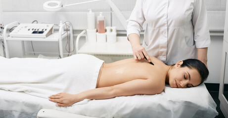 Obraz na płótnie Canvas Chinese massage gouache. Woman while back gouache massage for body detoxify