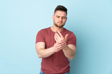Russian handsome man over isolated background suffering from pain in hands