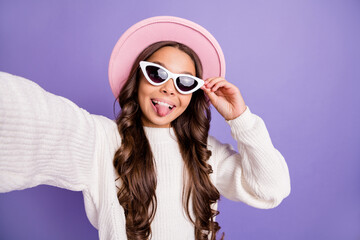 Photo of young girl happy smile tongue-out have fun wear sunglass make selfie isolated over violet color background