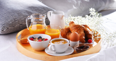 A tray with breakfast on a bed in a hotel room