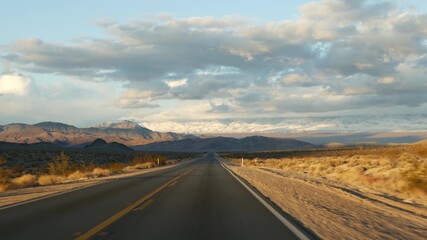 Fototapeta na wymiar Road trip, driving auto from Death Valley to Las Vegas, Nevada USA. Hitchhiking traveling in America. Highway journey, dramatic atmosphere, sunset mountain and Mojave desert wilderness. View from car.
