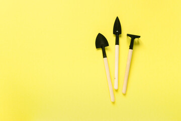 Set of garden tools. Shovels and rake on yellow background, space for text