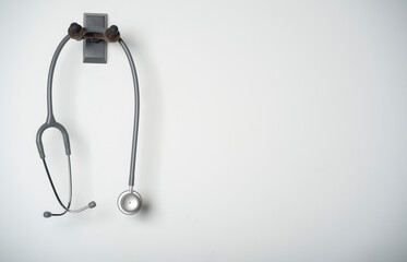 stethoscope equipment of doctor with is hanging on the white wall background