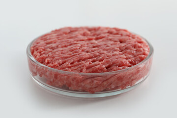 Petri dish with raw minced cultured meat on white table, closeup