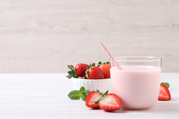 Delicious drink with strawberries on white wooden table, space for text