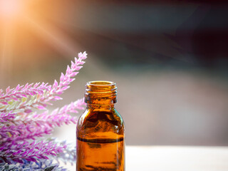 The essential oil or aromatherapy glass dropper on wooden background with flare light.