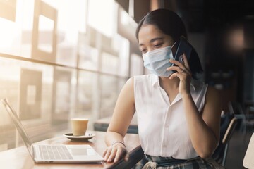 woman wearing surgical mask talking cellphone.
