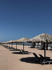 Beautiful lounge pavilion canopy for relax on the beach with sea side view and blue sky. Tent made of dry palm leaves. Luxury summer vacation in tropical paradise resort hotel