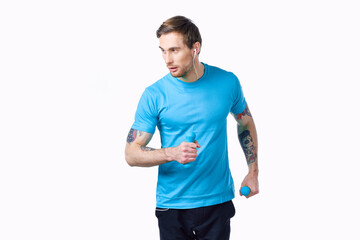 sporty man with a tattoo on his arm in a blue t-shirt and muscles bodybuilding fitness