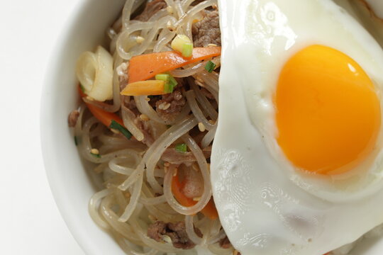 sunny side up fried egg on Korean Japchea green noodles stir fried