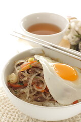 sunny side up fried egg on Korean Japchea green noodles stir fried