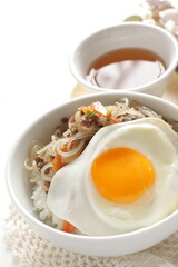 sunny side up fried egg on Korean Japchea green noodles stir fried