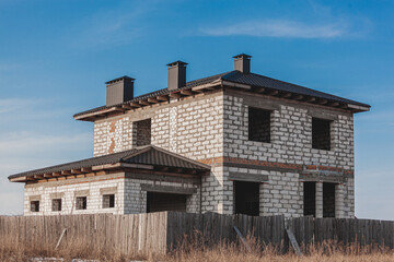 Fototapeta na wymiar Abandoned unfinished empty house no windows, abandoned construction concept