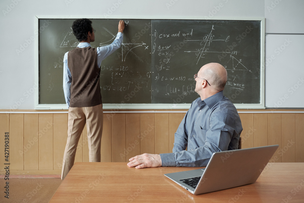 Aufkleber mature bald professor sitting by desk and looking at student standing by blackboard, drawing graph a