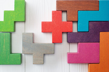 Fototapeta premium Concept of creative, logical thinking. Different colorful shapes wooden blocks on white wooden background.