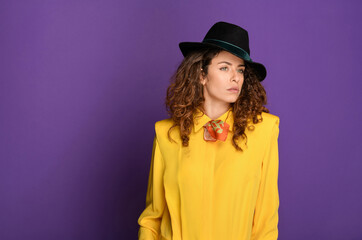Glamorous young woman in 80s fashion wearing fedora hat