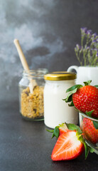 Ingredients for a delicious and healthy breakfast. Yogurt, granola, ripe strawberries. Image with selective focus