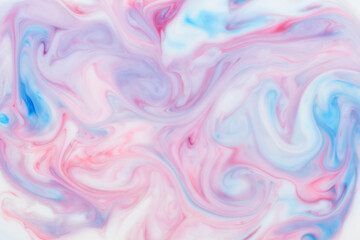 Swirling artistic blend of blue and pink ink in an abstract background