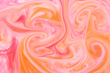 Abstract background texture of swirling orange and pink ink