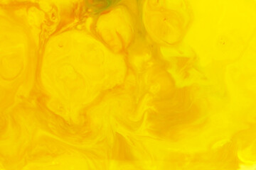 Vibrant yellow abstract amorphous background of swirling ink