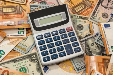 Business financial accounting dollar and euro banknotes with calculator on desk