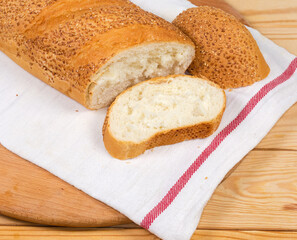 Partly cut wheat bread sprinkled with sesame on napkin