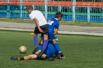 Children's football. Children are playing football. The active struggle and dynamics of the boys' soccer match. The boys are recklessly fighting for the ball