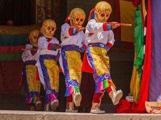 Dancers with traditional costumes and masks during a religious performance in the ancient Kumbum...