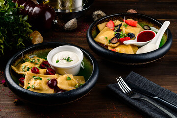 homemade dumplings, vareniki with blueberry fillings in bowl on a dark rustic table with fresh berries