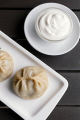 Khinkali with sauce. Georgian traditional dumplings Khinkali with meat on white plate. Caucasuan cuisine.