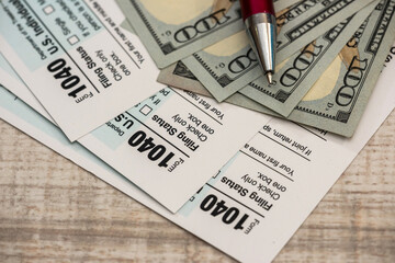 Obraz premium pen and dollar bills and US 1040 tax form