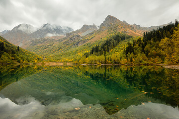 Beautiful autumn landscape, mountain lake, coniferous forest, mirror reflection. Russia, Kardyvach