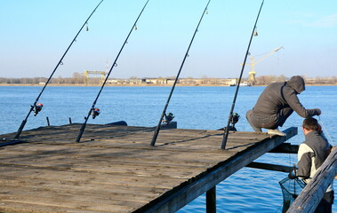 ishing reel on the rod. Fishing on the feeder. Carp fishing rods with carp bite indicators and reels set up on rod pod near lake river.