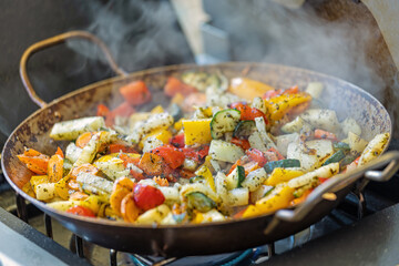 Grillgemüse in einer Pfanne auf dem Seitenbrenner eines Gasgrills