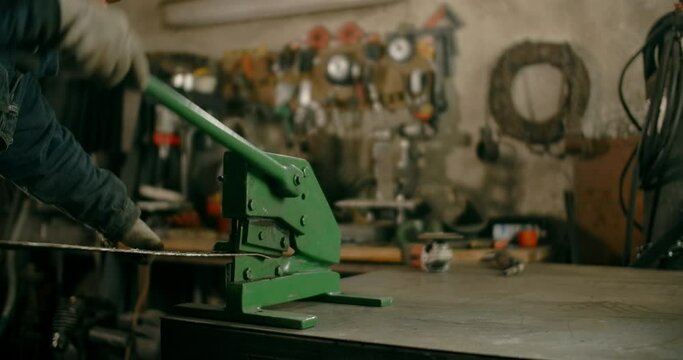 Locksmith uses guillotine mechanical sheet metal cutter at his workshop, manual metalwork, 4k Prores HQ